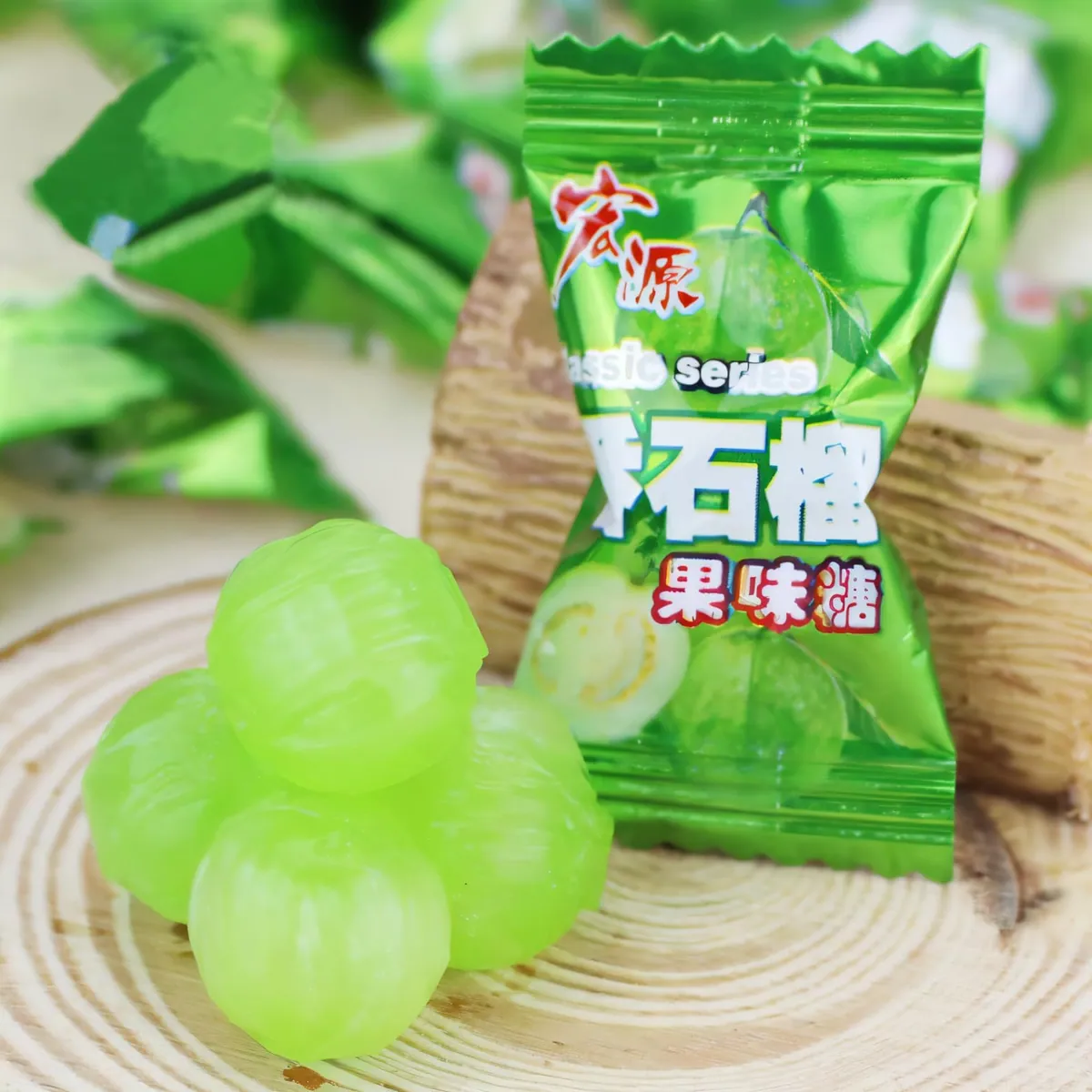 Unwrapped green guava candies beside a wrapped piece